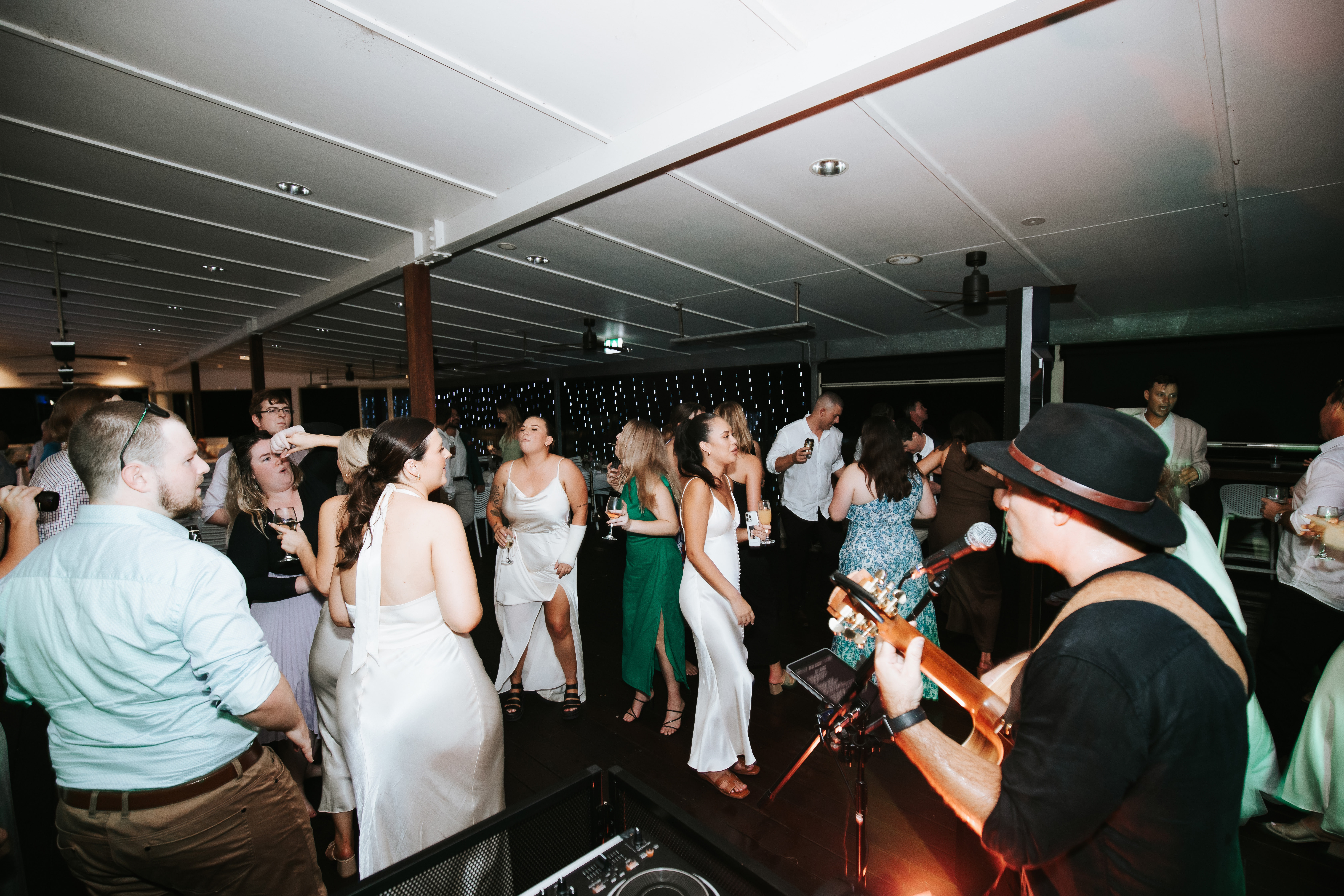 Ryan Martin playing to a crowded Yamba Golf Club deck while wedding guests dance
